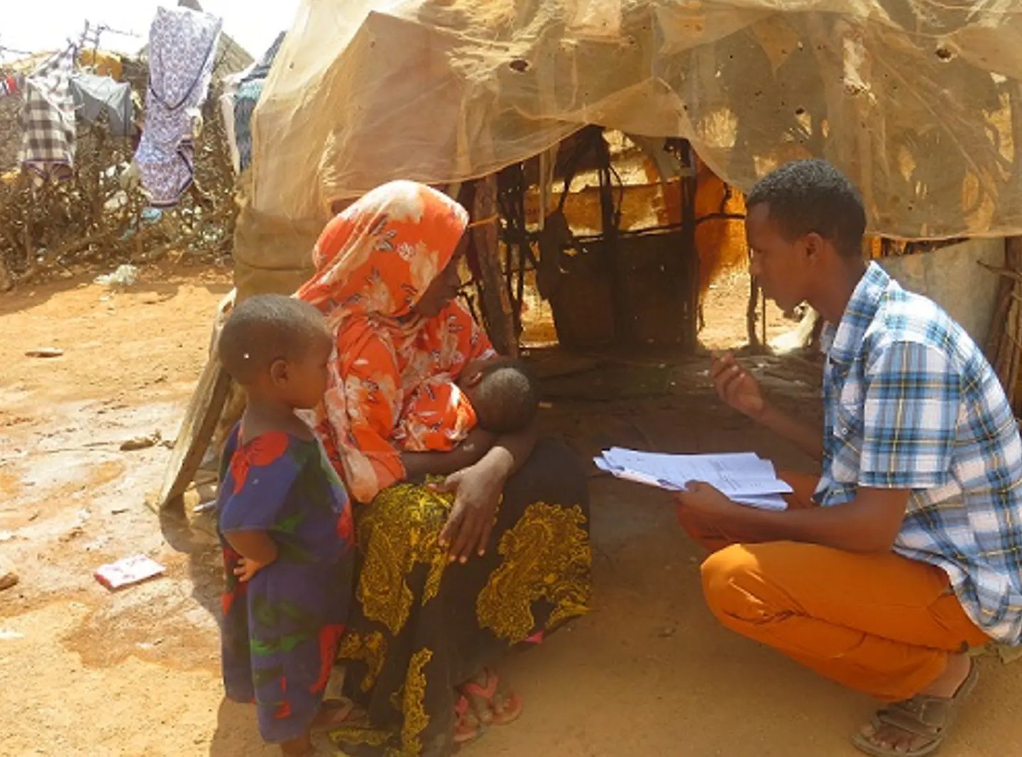 A JCC protection monitor interviewing a mother and her children during a household visit