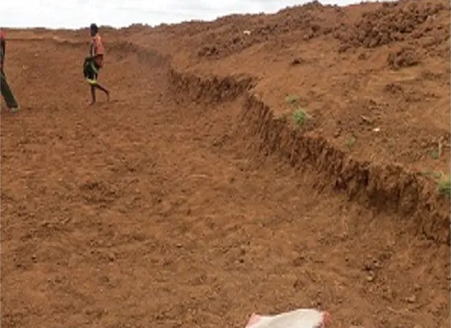 Freshly cut embankment with a worker walking the length of the spoil heap